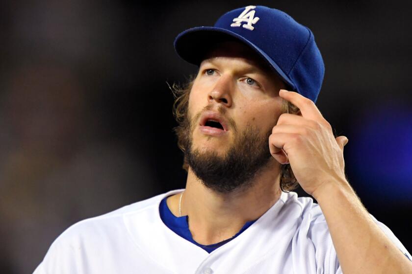 Clayton Kershaw pulls hair away from his face.