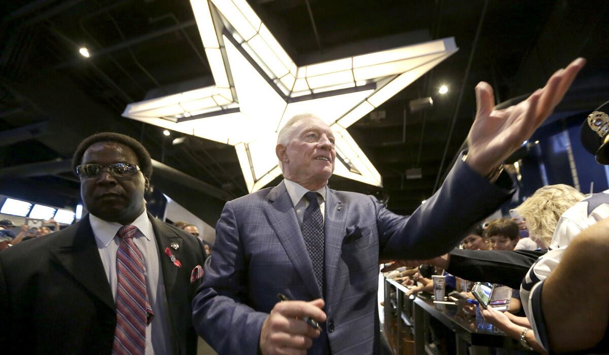 Cowboys owner Jerry Jones signs autographs for fans before a game last month in Arlington, Texas.