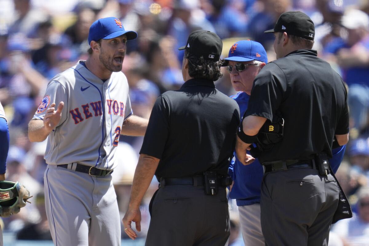 New York Mets pitcher Max Scherzer and manager Buck Showalter dispute a call from umpires Phil Cuzzi and Dan Bellino.