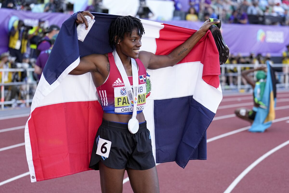 La dominicana Marileidy Paulino festeja con su bandera tras conseguir la plata 