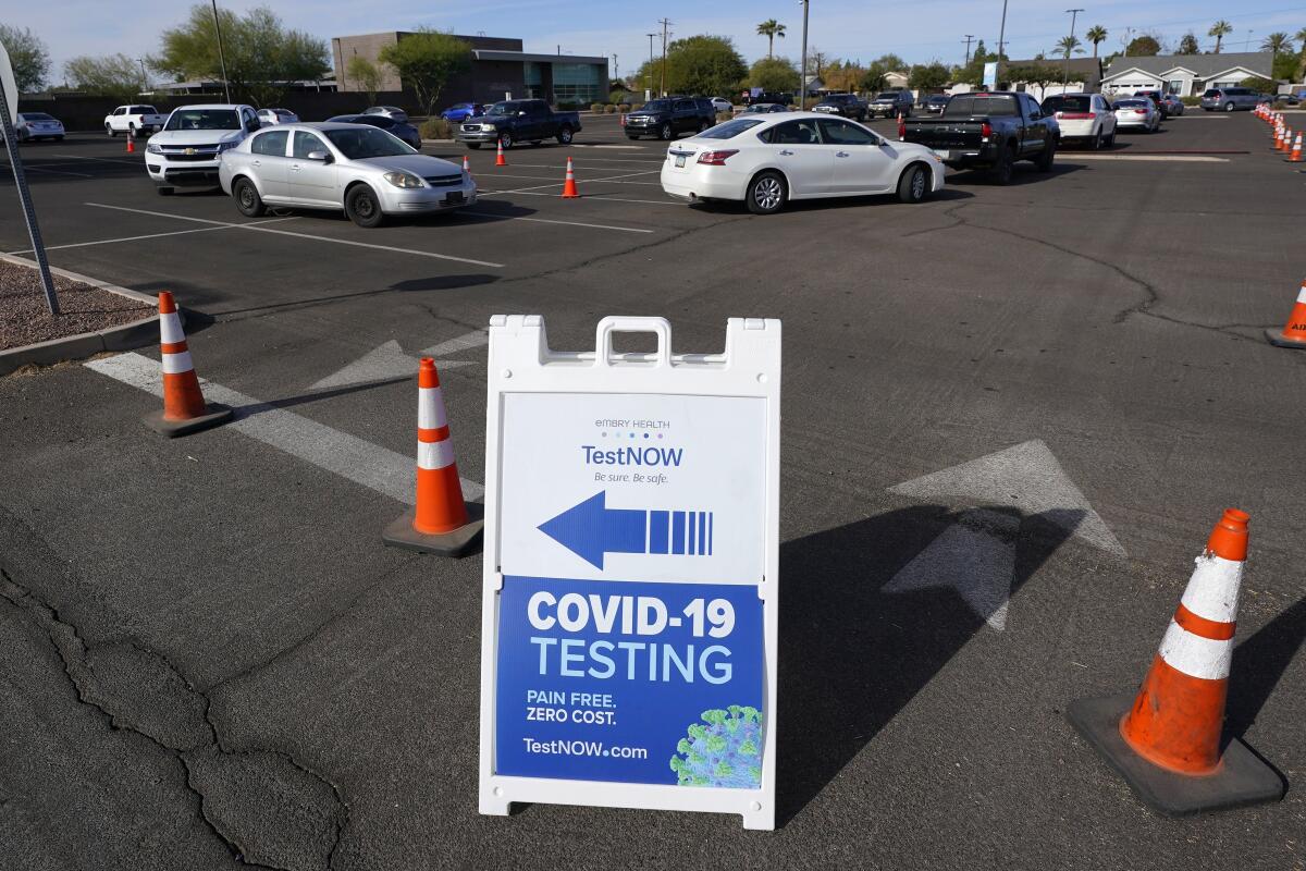 Personas esperan en sus vehículos para hacerse la prueba del COVID-19, en Phoenix, Arizona.