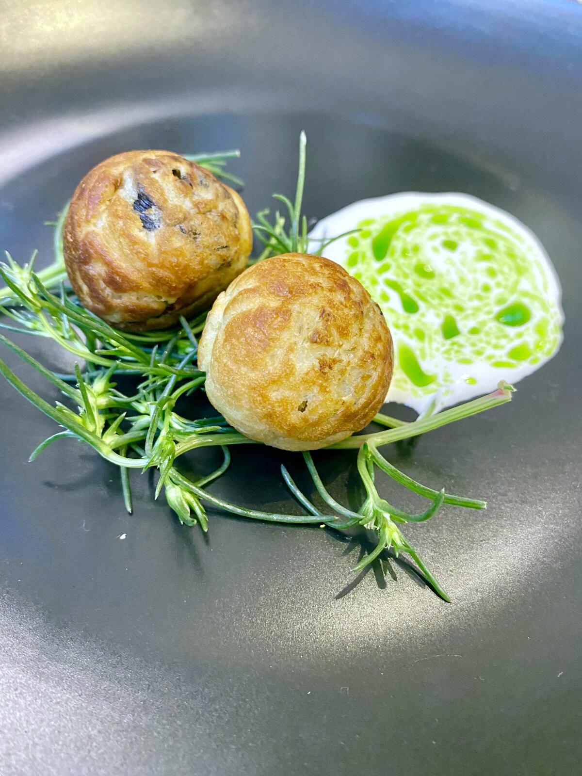 Escargot aebelskivers with sauerkraut, buttermilk and parsley at Popularie at South Coast Plaza on May 31.