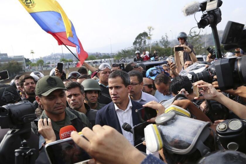 A Juan Guaidó, en el centro, se le unen en Caracas soldados que respondieron a su llamado a un levantamiento militar contra el presidente Nicolás Maduro. (Fernando Llano / Associated Press)