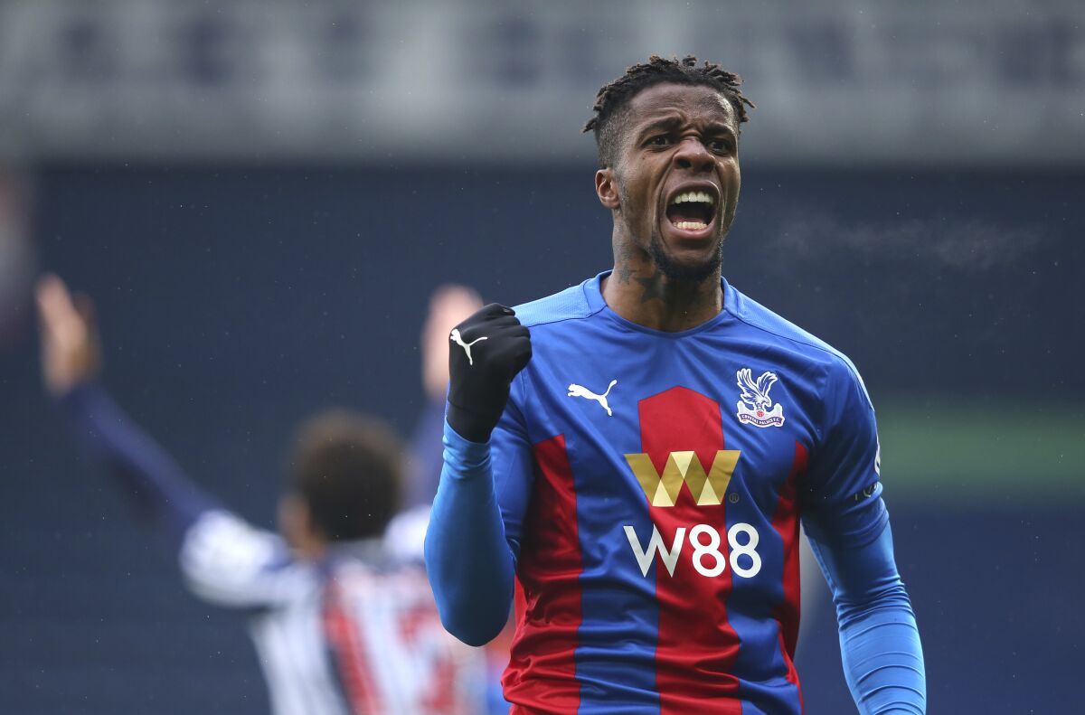 Crystal Palace's Wilfried Zaha celebrates after his shot is turned in by West Bromwich Albion's Darnell Furlong for the first goal during the English Premier League soccer match between West Bromwich Albion and Crystal Palace at the Hawthorns, West Bromwich, England, Sunday, Dec. 6, 2020. (Alex Livesey/Pool via AP)