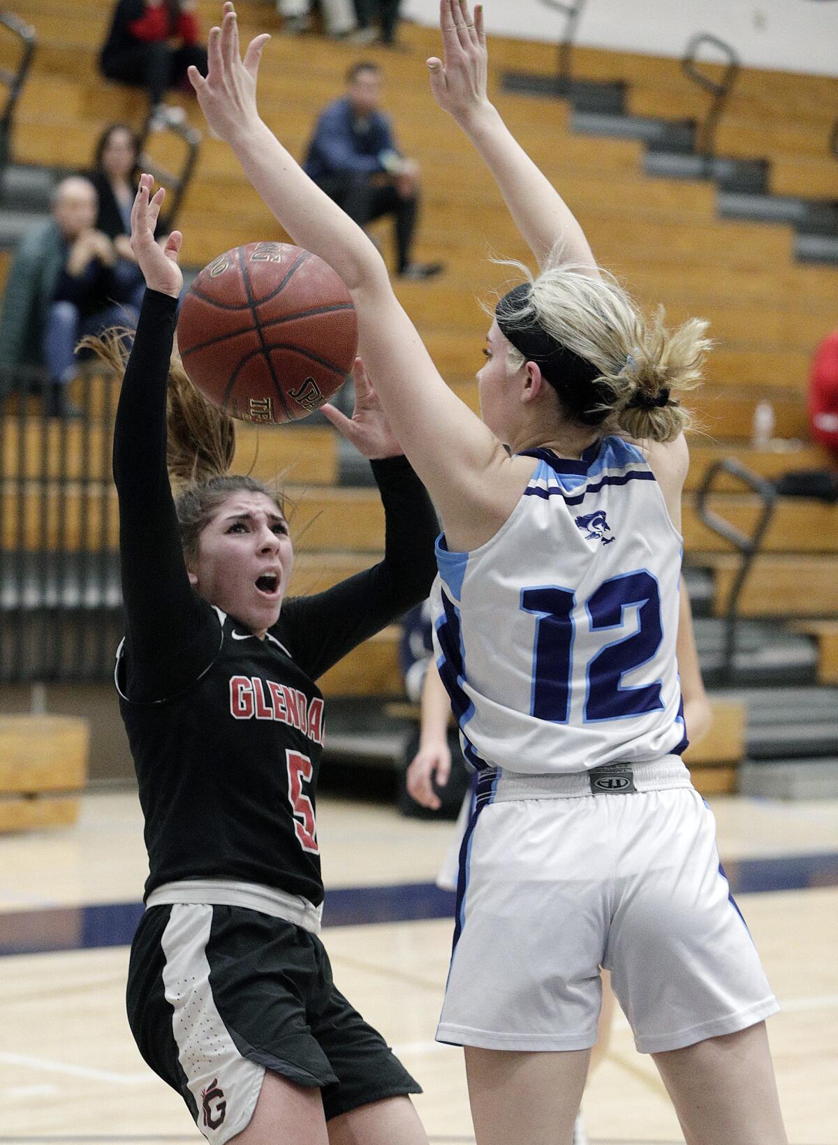 Glendale's Ani Boyajyan drives into the outstretched arms of Crescenta Valley's Lily Geck and attempts to shoot in a Pacific League girls' basketball game at Crescenta Valley High School on Tuesday, January 7, 2020.