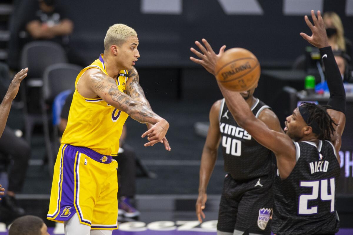 Lakers forward Kyle Kuzma passes the ball past Kings guard Buddy Hield.
