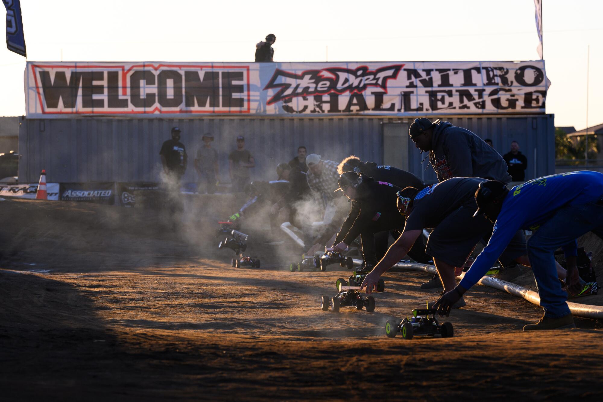 Pit crew members launch their team's RC cars
