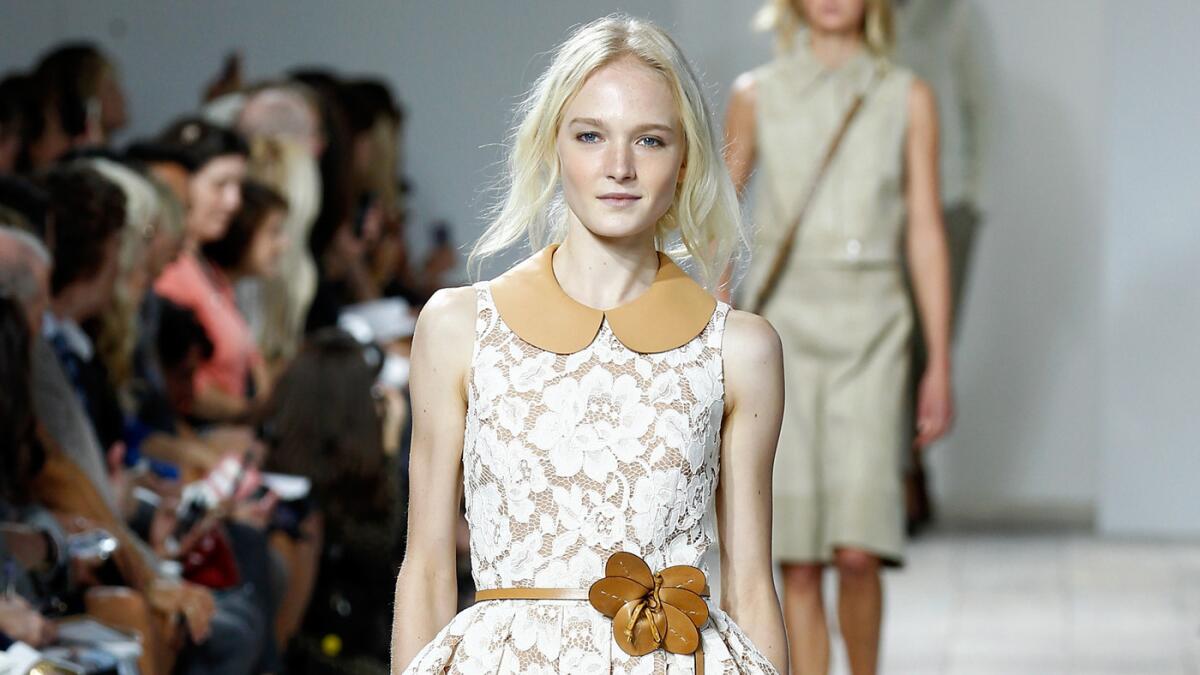 A model wears a white lace dress with leather collar from the Michael Kors Spring/Summer 2015 show.