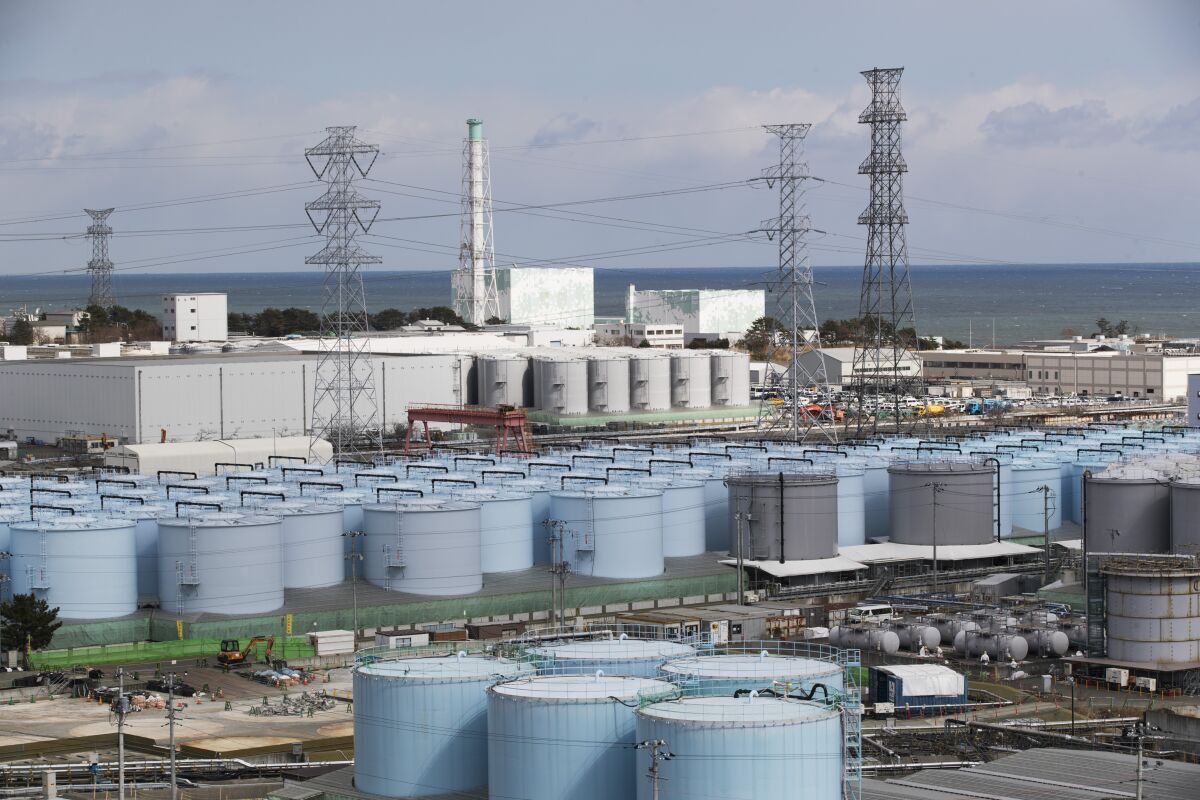 FILE - In this Saturday, Feb. 27, 2021, file photo, Nuclear reactors of No. 5, center left, and 6 look over tanks storing water that was treated but still radioactive, at the Fukushima Daiichi nuclear power plant in Okuma town, Fukushima prefecture, northeastern Japan. Japanese Prime Minister Fumio Kishida on Sunday, Oct. 17 visited the tsunami-wrecked Fukushima nuclear plant and said a planned disposal of the massive wastewater stored on the complex cannot be delayed and that his government will explain the safety of the project with scientific evidence to gain understanding from local residents. (AP Photo/Hiro Komae, file)