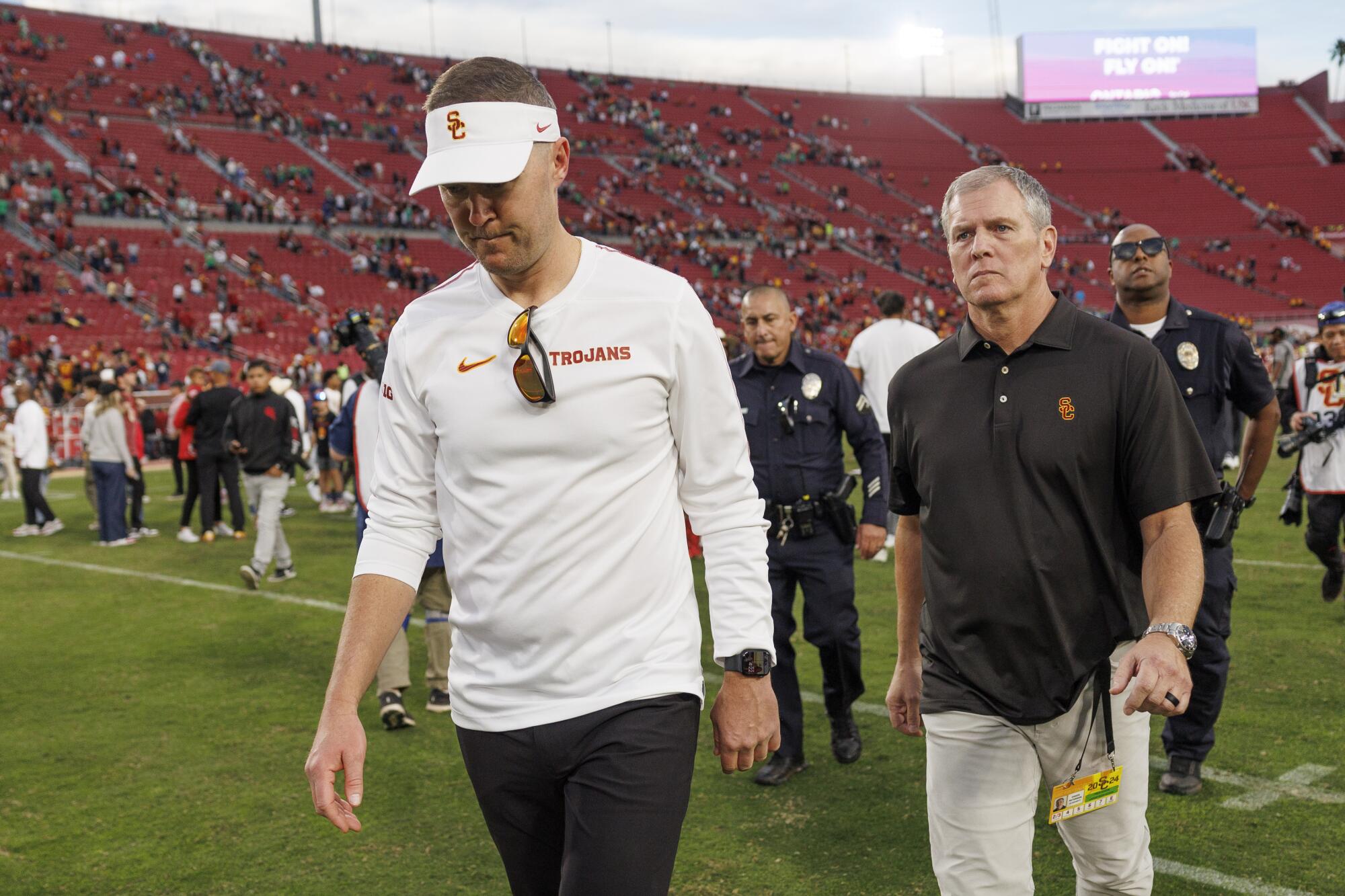 USC coach Lincoln Riley looks down and leaves the field after the Trojans 49-35 loss to Notre Dame Saturday