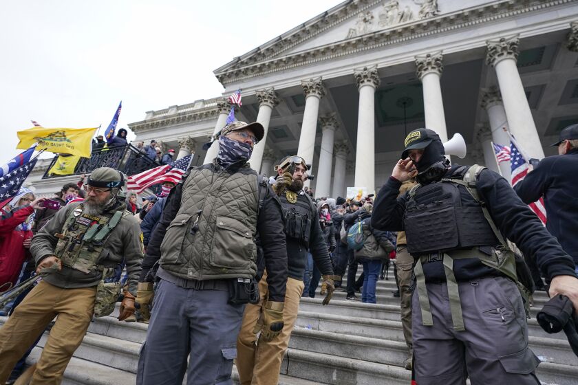 FILE - Members of the Oath Keepers stand on the East Front of the U.S. Capitol on Jan. 6, 2021, in Washington. Federal prosecutors on Monday, Oct. 3, will lay out their case against the founder of the Oath Keepers' extremist group and four associates charged in the most serious case to reach trial yet in the Jan. 6, 2021 U.S. Capitol attack. (AP Photo/Manuel Balce Ceneta, File)