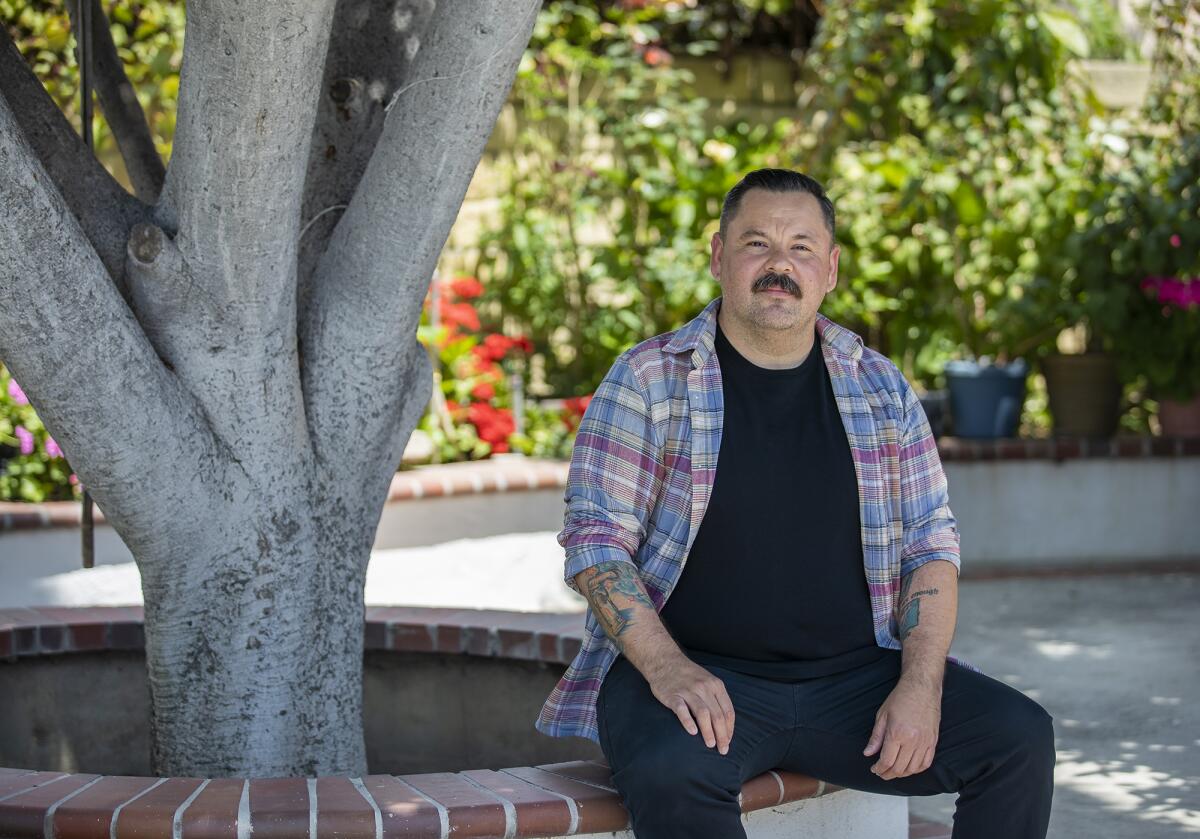 Gustavo Hernandez sitting in his mom's yard in Santa Ana.