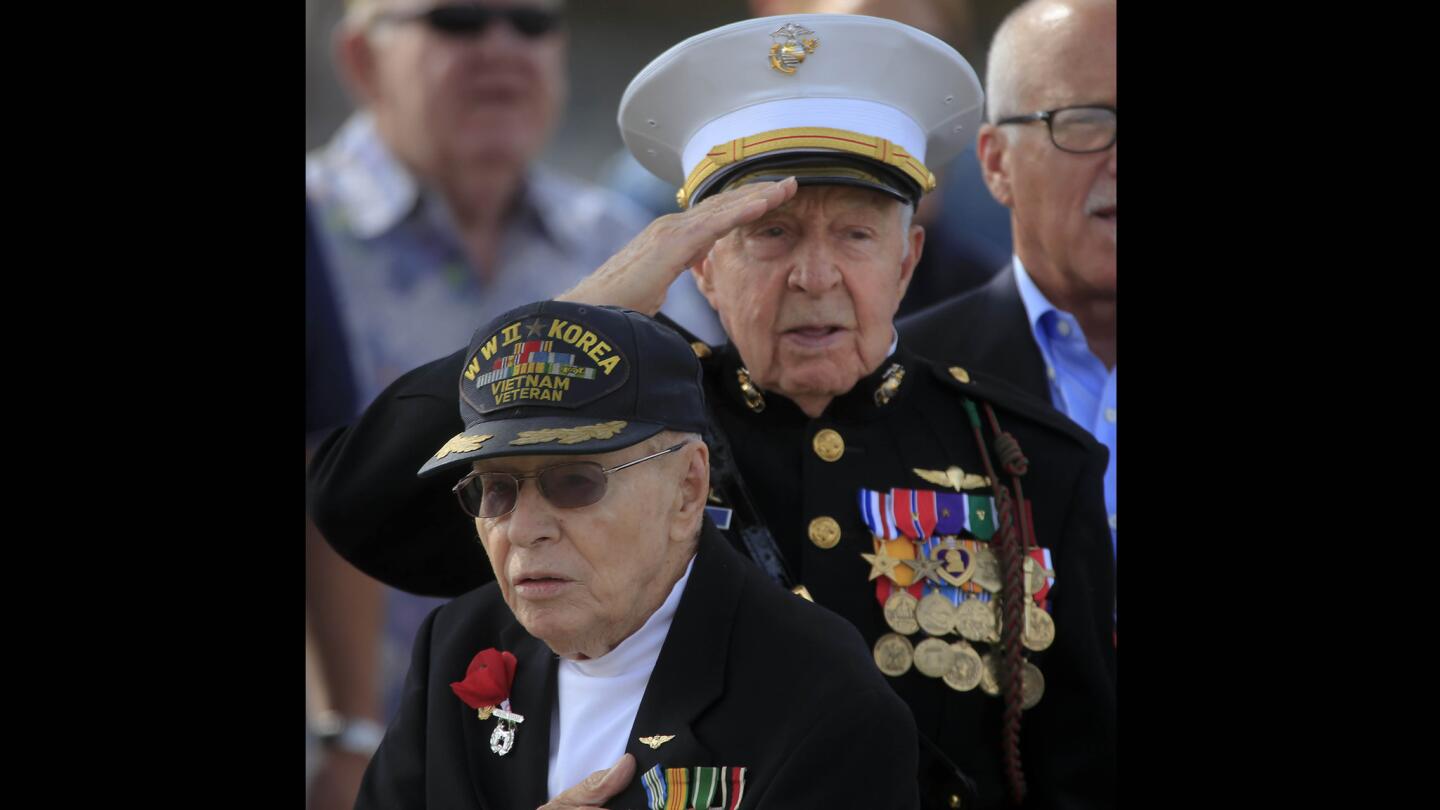 Retired Lt. Col. William R. Duncan, a veteran of World War ll and the Korean and Vietnam wars, and Tom Evans, a former Marine Corps platoon sergeant who served during WW II and the Korean War, salute during the singing of the national anthem at the Newport Beach American Legion Veterans Day observance on Nov. 11.