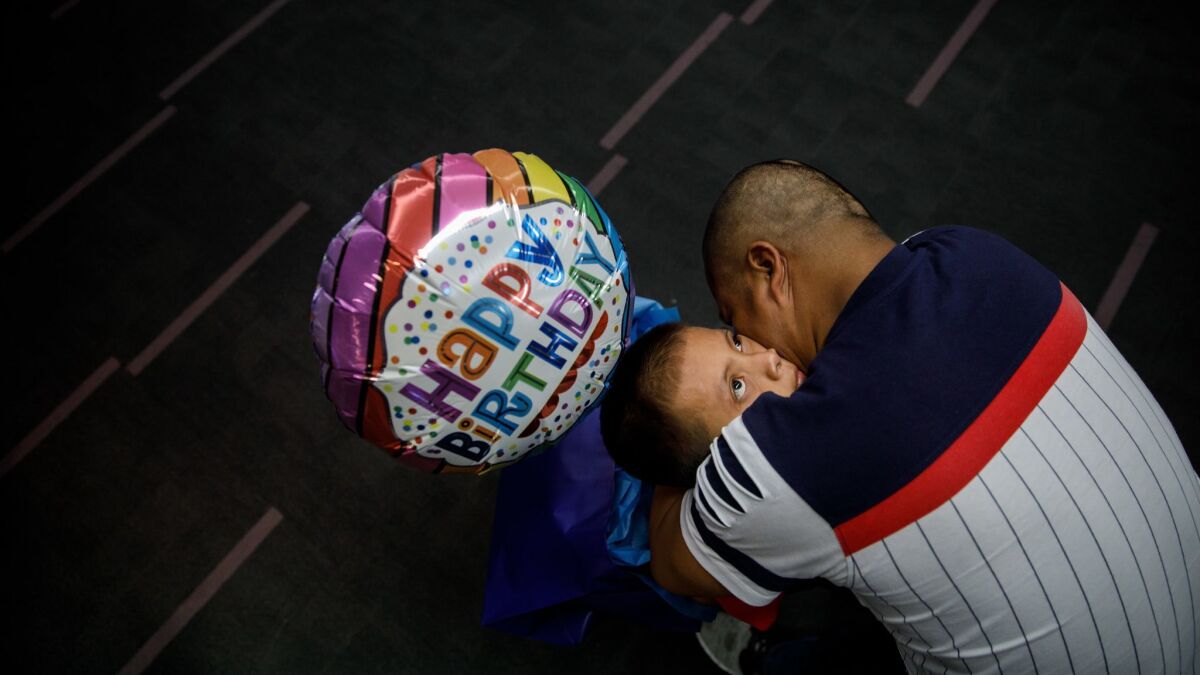 Guatemalan asylum seeker Hermelindo Che Coc embraces his 6-year-old son, Jefferson Che Pop, as they reunite at LAX.