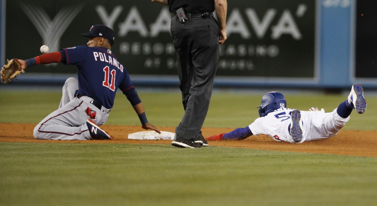 Dodgers right fielder Mookie Betts steals second as Twins second baseman Jorge Polanco can't get a glove on the throw.