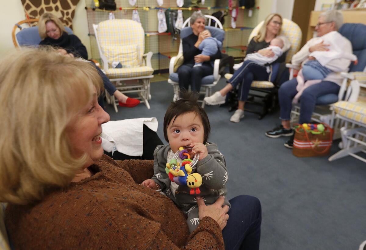 Volunteer "holder" Cathy Nordin plays with a child at the Assistance League of Laguna Beach's early intervention program.