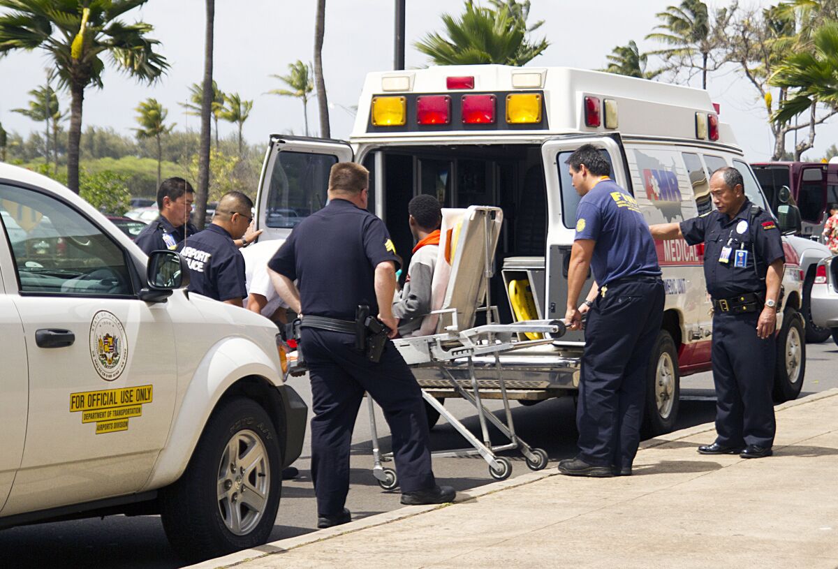 A 16-year-old boy, seen sitting on a stretcher center, who stowed away in the wheel well of a flight from San Jose, Calif., to Maui is loaded into an ambulance at Kahului Airport in Kahului, Maui, Hawaii Sunday afternoon.