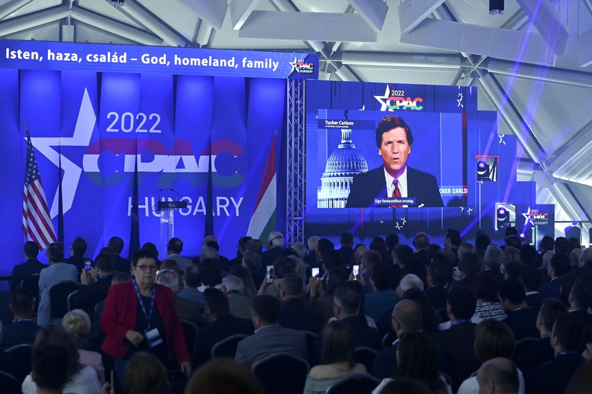 American television host and conservative political commentator Tucker Carlson is seen on screen delivering a speech at the CPAC conference in Budapest, Hungary, Thursday, May 19, 2022. Dozens of prominent conservatives from Europe, the United States and elsewhere have gathered in Hungary for the American Conservative Political Action Conference, being held in Europe for the first time. The two-day event represents a deepening of ties between the American right wing and the autocratic government of Prime Minister Viktor Orban. (Szilard Koszticsak/MTI via AP)