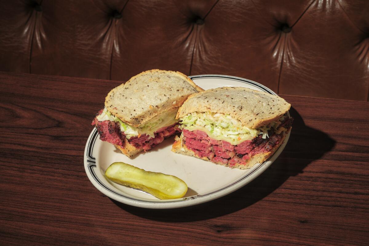The #19 pastrami sandwich at Langer's Deli, cut in half with a pickle spear on a plate