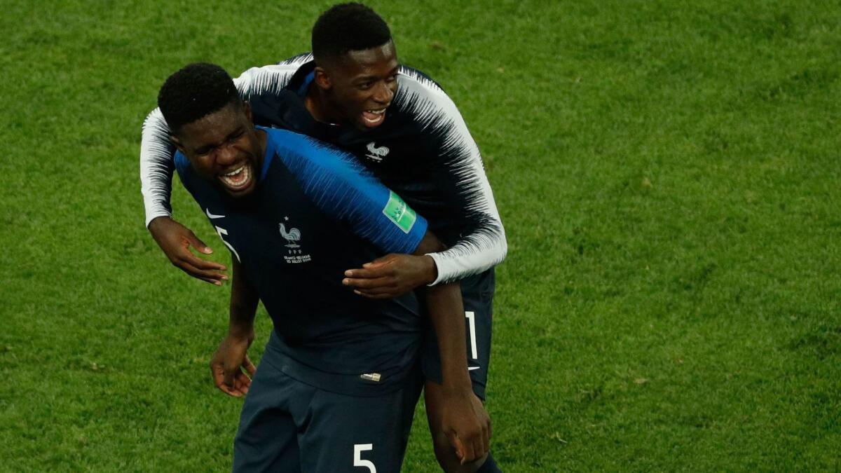 France's Samuel Umtiti, left, and Ousmane Dembele celebrate after their team beat Belgium in a World Cup semifinal match on July 10.