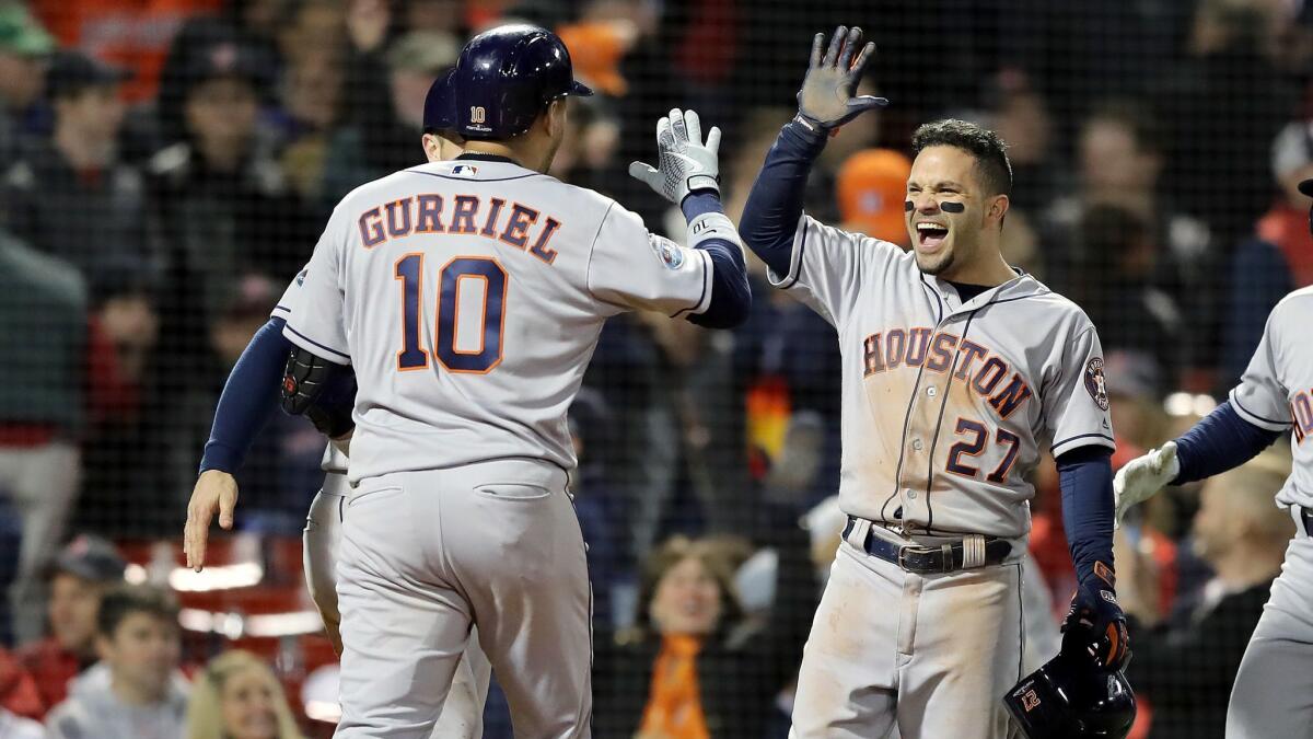 Houston Astros' Yuli Gurriel is congratulated by his teammates after his three-run home run during the ninth inning against the Boston Red Sox in Game 1 of the American League Championship Series at Fenway Park on Saturday in Boston.