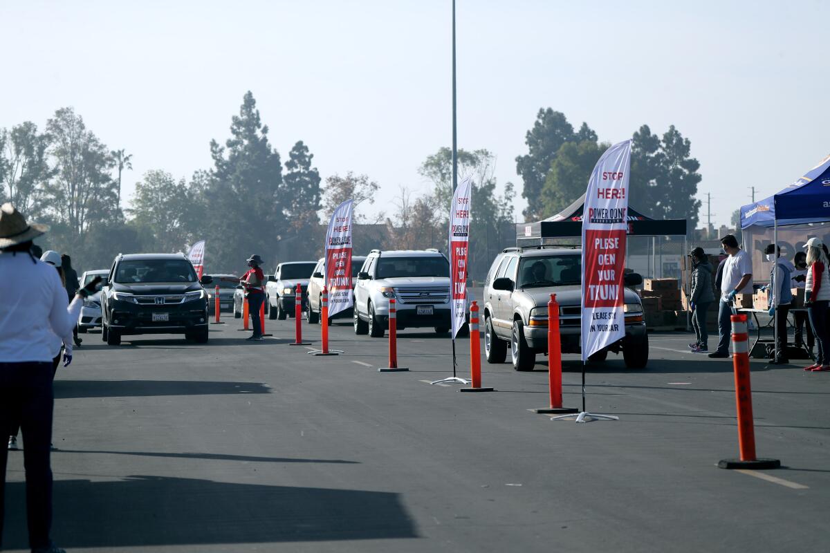 Rows of vehicles line up at the Power of One Foundation Thanksgiving food giveaway at the O.C. Fair & Event Center.