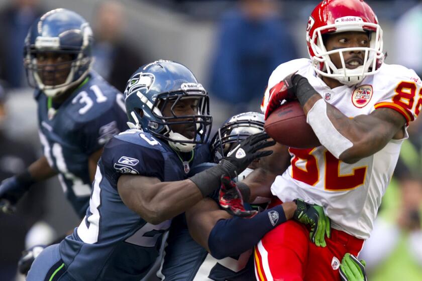 Chiefs receiver Dwayne Bowe (82) tries to break through the tackles of Seattle Seahawks cornerback Marcus Trufant (23) and safety Earl Thomas (29), during a game in Seattle.