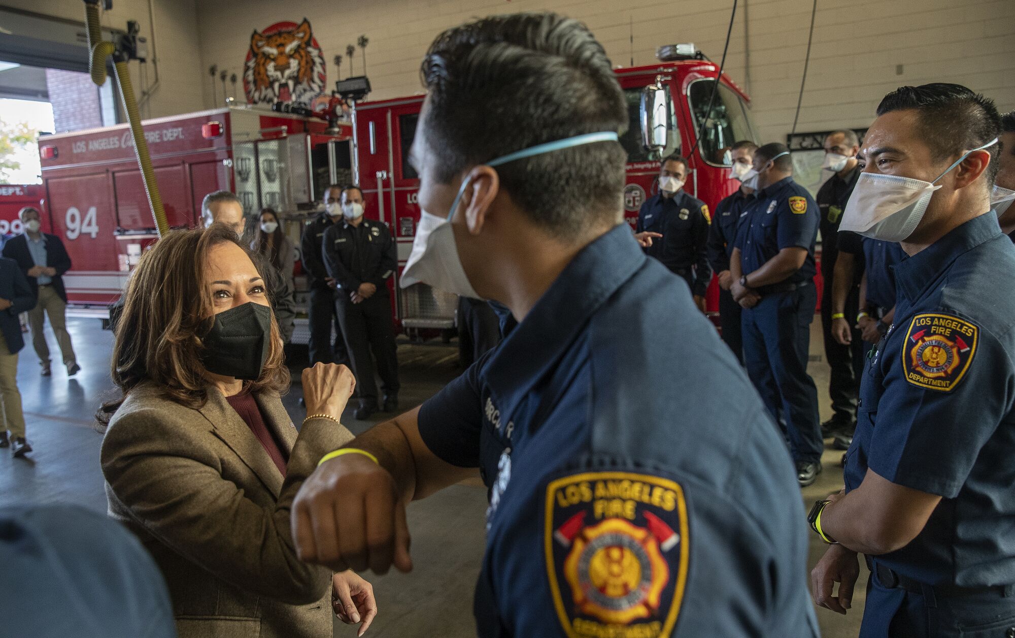 Vice President Kamala Harris and firefighter Adam Corcuera share an elbow bump