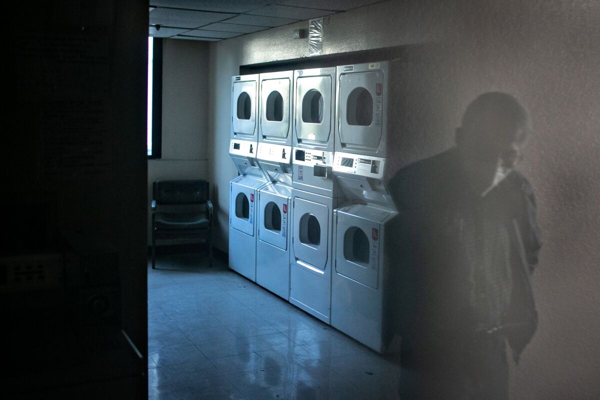 A resident of Cathay Manor in Chinatown points out the laundry room being out of service for an extended period.