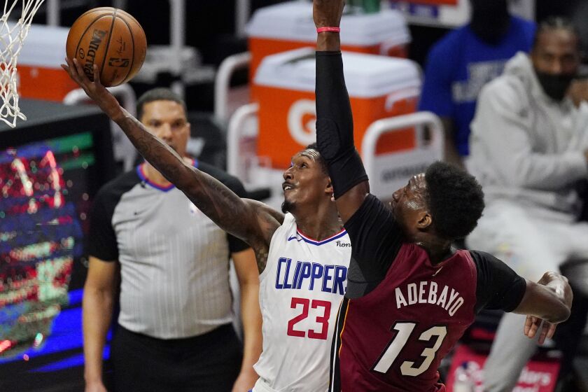 Los Angeles Clippers guard Lou Williams, left, shoots as Miami Heat center Bam Adebayo.