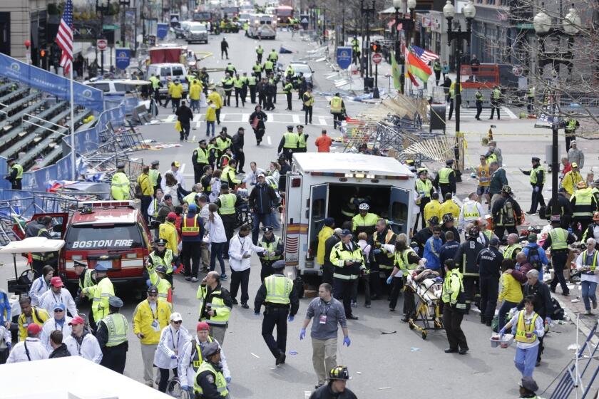 Medical workers aid injured people at the finish line of the 2013 Boston Marathon following two explosions Monday.