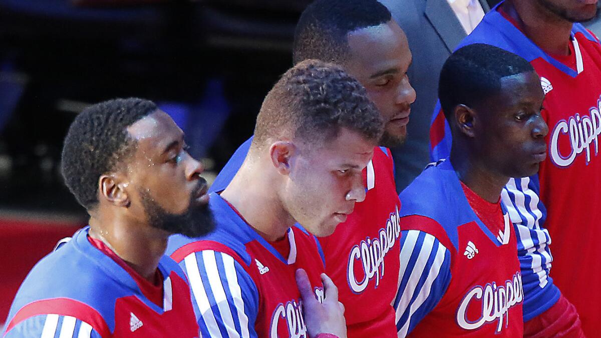 Clippers teammates, from left, DeAndre Jordan, Blake Griffin, Glen Davis and Darren Collison listen to the singing of the national anthem before the start of Game 5 of the Western Conference quarterfinals against the Golden State Warriors on Tuesday.