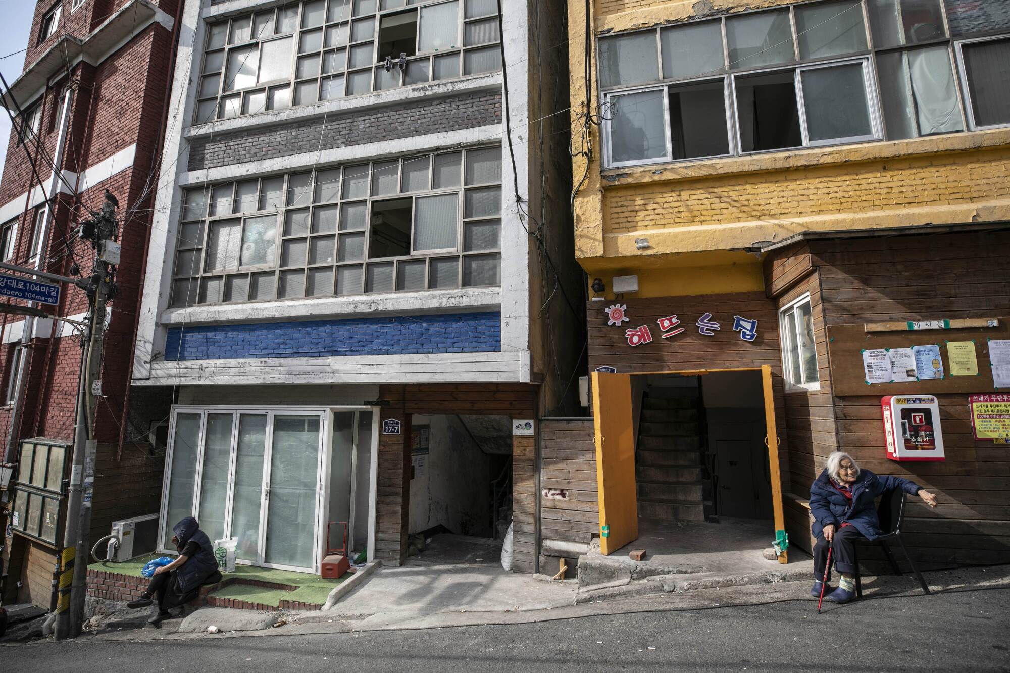 The residents of "Jjokbangchon" neighborhood of Dongja-dong sit outside the buildings that house Jjokbangs