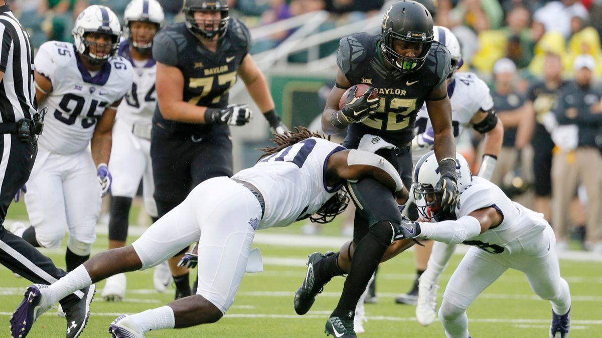 TCU safety Denzel Johnson (30) and safety Nick Orr, right, combine to stop Baylor running back Terence Williams (22) after a short run in the first half on Nov. 5, 2016.