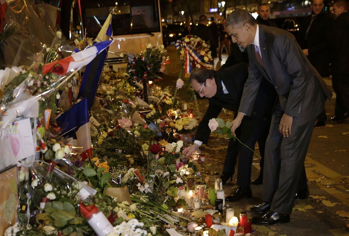 President Obama pays his respects with French President Francois Hollande at a memorial outside the Bataclan theater in Paris on Nov. 30.