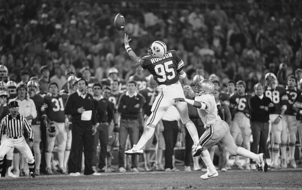 FILE - Brigham Young University tight end Gordon Hudson reaches up to make a one-handed catch for a 14-yard gain during the Holiday Bowl NCAA college football game against Ohio State in San Diego, in this Friday Dec. 17, 1982, file photo. Hudson, an All-American tight end for Brigham Young University and college football hall of famer, died Sept. 27, 2021. He was 59. He died in San Jose, California, the school said. (AP Photo/File)
