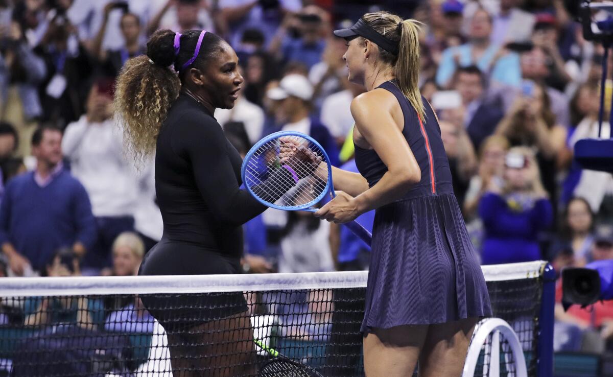 Serena Williams, left, shakes hands with Maria Sharapova after their first-round match at the U.S. Open on Monday.