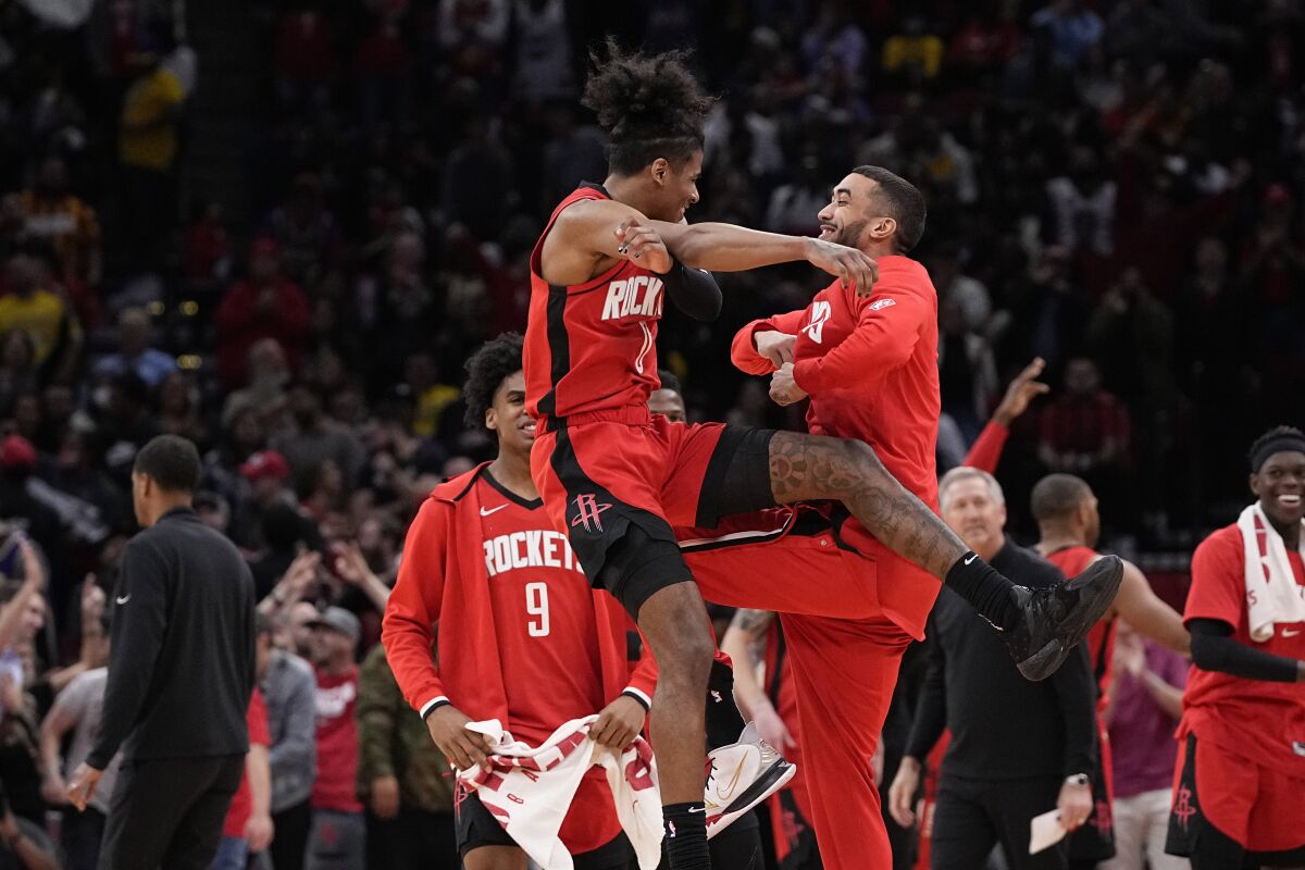 Houston Rockets' Jalen Green (0) celebrates with teammates after making a basket against the Los Angeles Lakers during overtime of an NBA basketball game Wednesday, March 9, 2022, in Houston. The Rockets won 139-130 in overtime. (AP Photo/David J. Phillip)