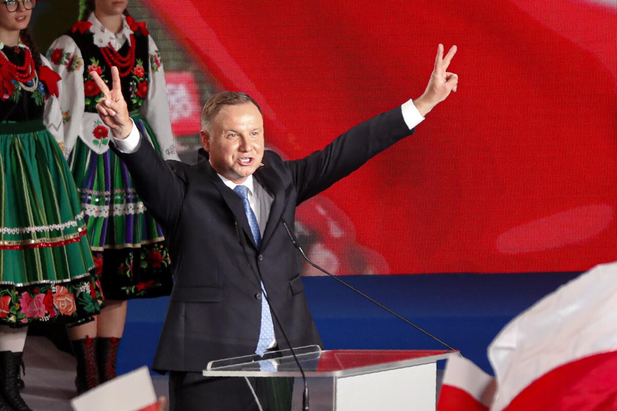 Polish President Andrzej Duda flashes victory signs during a stop in Lowicz on Sunday.