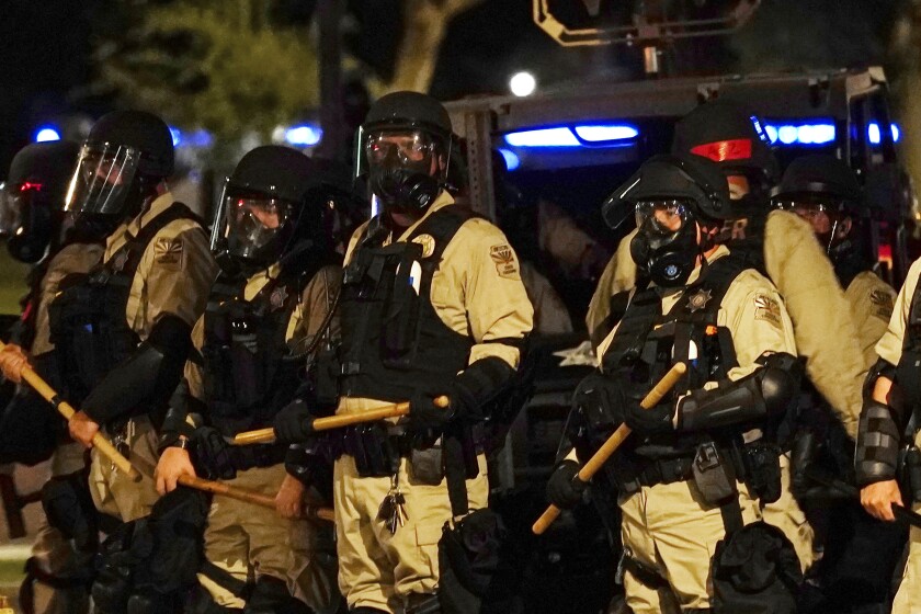 Police in riot gear surround the Arizona Capitol after protesters reached the front of the Arizona Sentate building as protesters reacted to the Supreme Court decision to overturn the landmark Roe v. Wade abortion decision Friday, June 24, 2022, in Phoenix. (AP Photo/Ross D. Franklin)