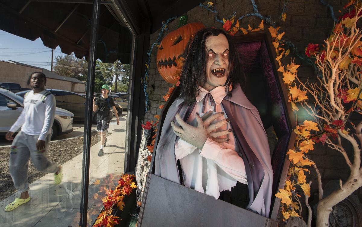 Customers walk past a Halloween store in Burbank on Oct. 10. 