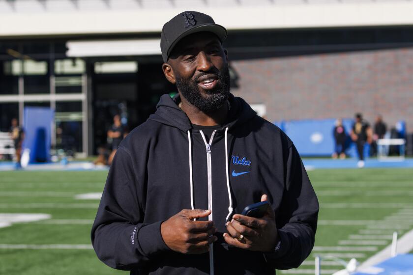 UCLA coach DeShaun Foster stands on the practice field.