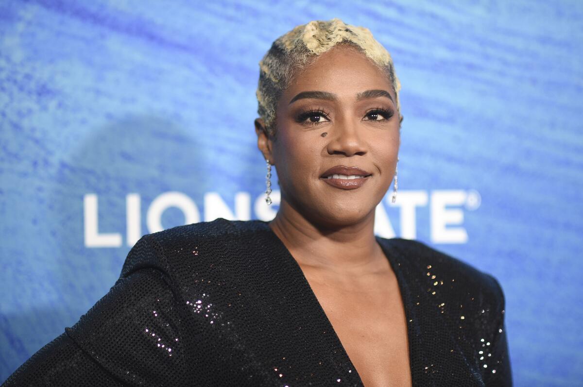 A woman in a black, sparkling dress at a movie premiere