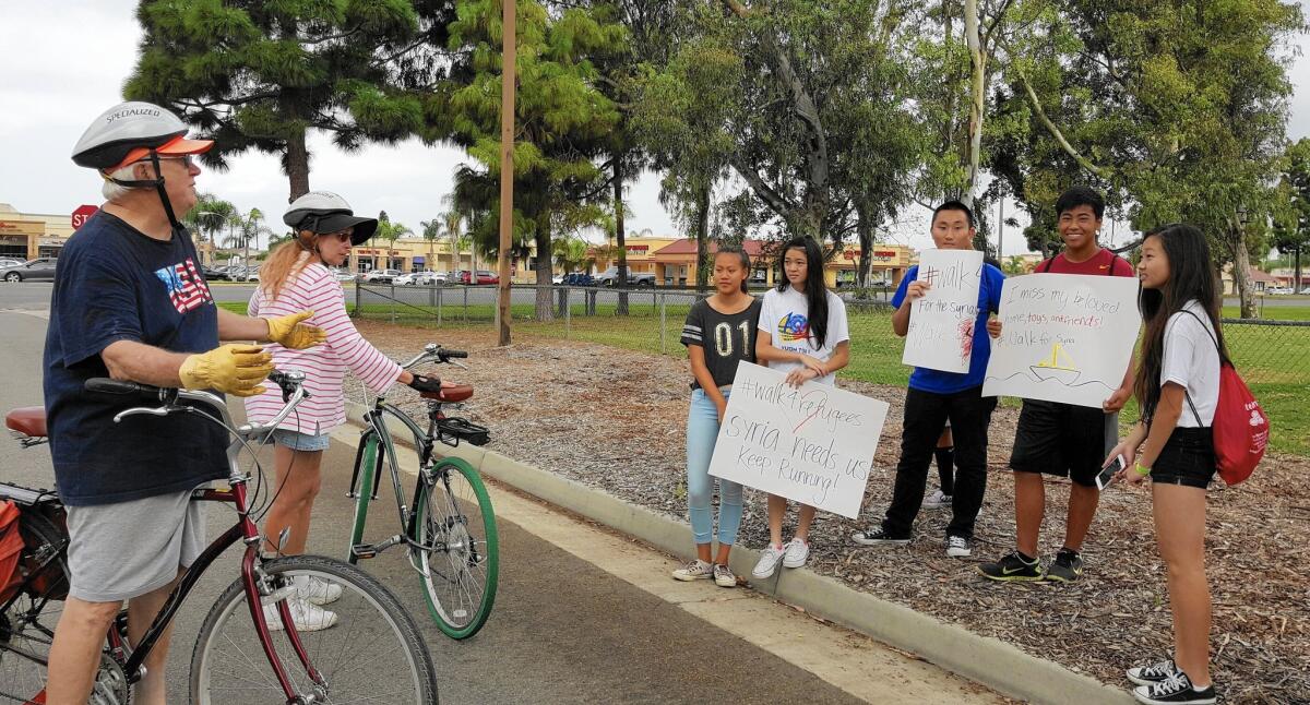 A group of students from Fountain Valley High School in Orange County hold signs for #Walk4Refugees, a walkathon to benefit Syrians fleeing civil war.