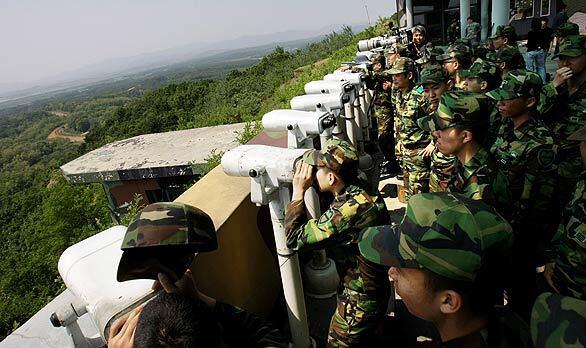 South Korean soldiers look into North Korea from an observation post near the border village of Panmunjom. North Korea warned South Korea and the United States that Seoul's participation in a U.S.-led program to intercept ships suspected of carrying weapons of mass destruction is equal to a "declaration of war."
