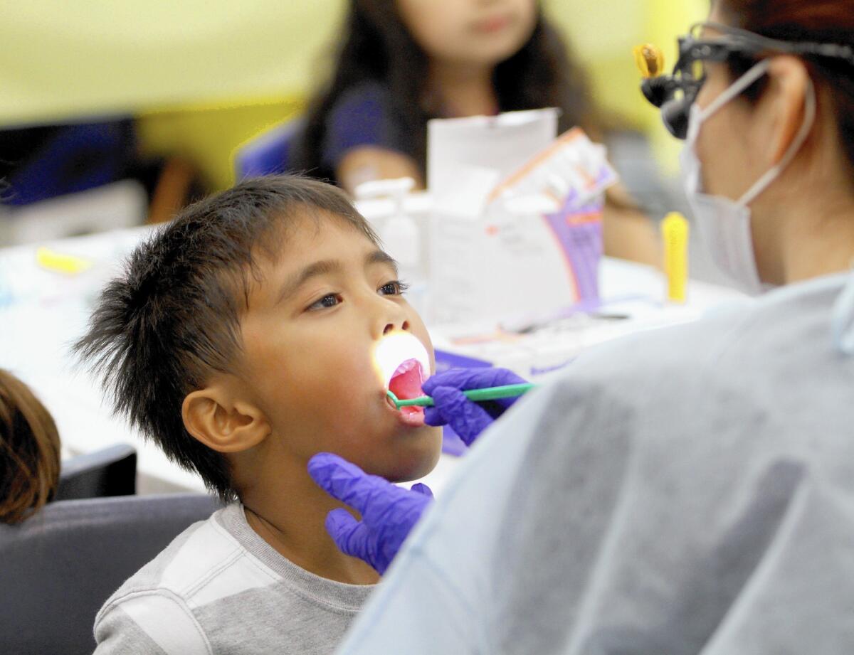 Providencia Elementary School first-grader Seth Malapote gets his teeth checked during a visit by the Kids Community Dental Clinic to his school, in Burbank on Wednesday, Feb. 17, 2016. The free clinic offered free dental checkups for 450 students, all provided by West L.A. College Dental Hygiene students and three volunteer dentists.