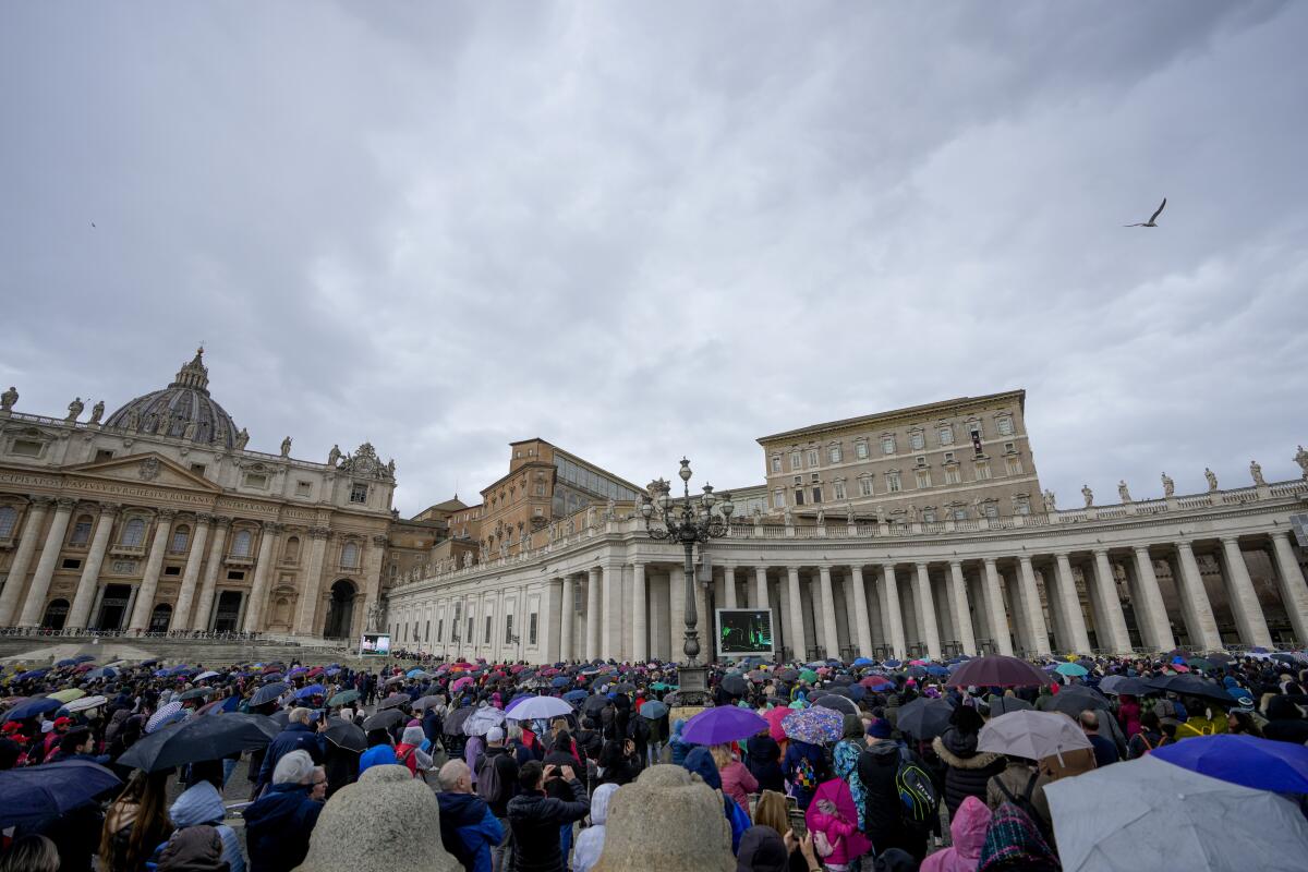 People crowd St. Peter's Square at the Vatican as Pope Francis delivers a blessing.