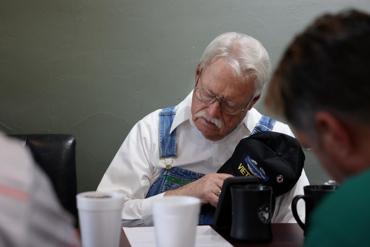 A group of men start Bible study with a prayer, including Bobby Don Shelton, 76