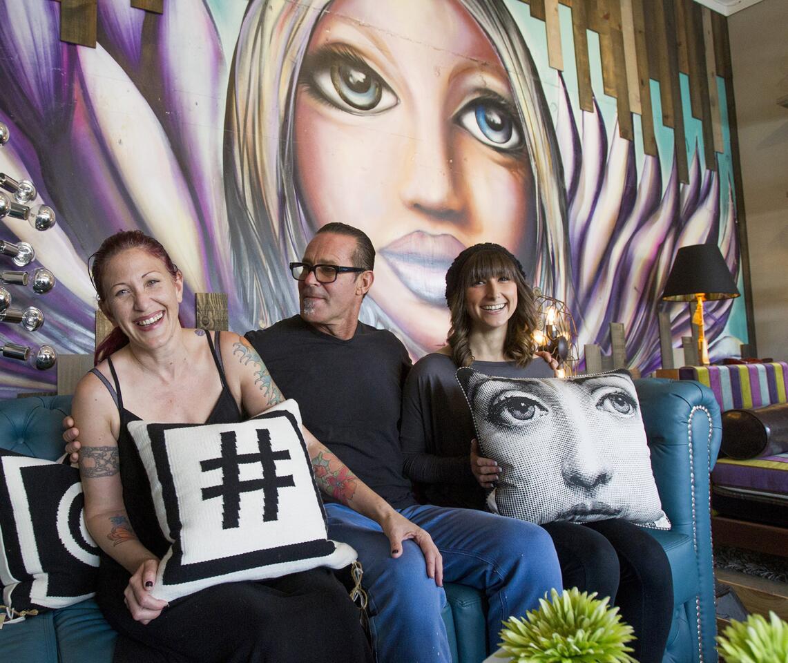 Davis Ink Ltd. owners Andrea, left, and husband Davis Krumins, center, and lead designer Sara Hernandez pose for a portrait at their office located along the 1600 block of Superior Avenue in Costa Mesa. The company creates interior designs for hospitality and nightclub venues. (Kevin Chang/ Daily Pilot)