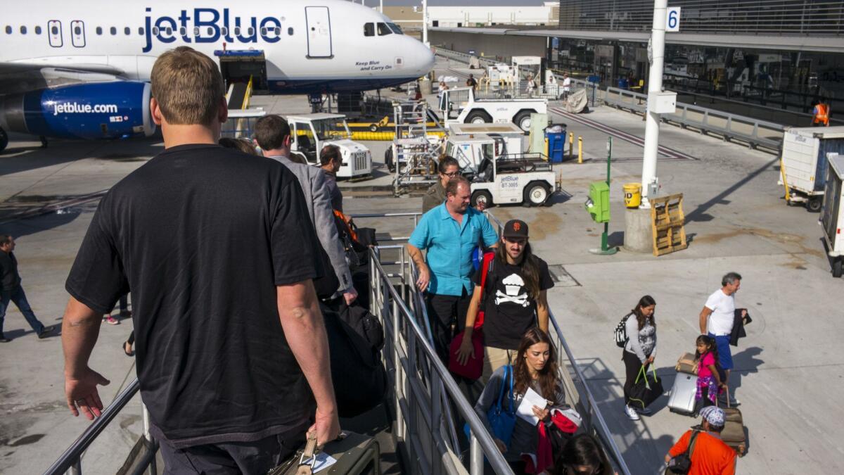 Passengers disembark from a JetBlue Airways plane at Long Beach Airport.